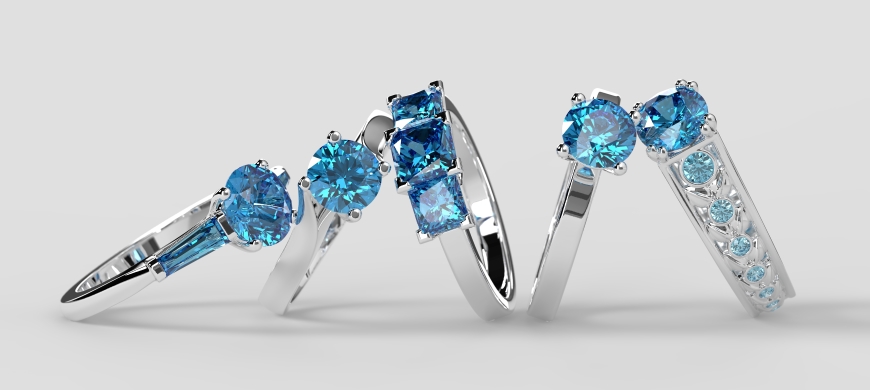 Five aquamarine engagement rings leaning against each other