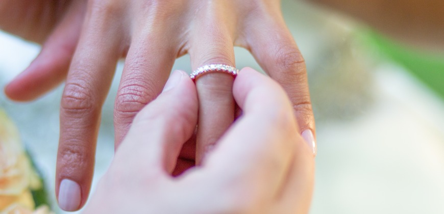 Person putting an eternity ring on their finger