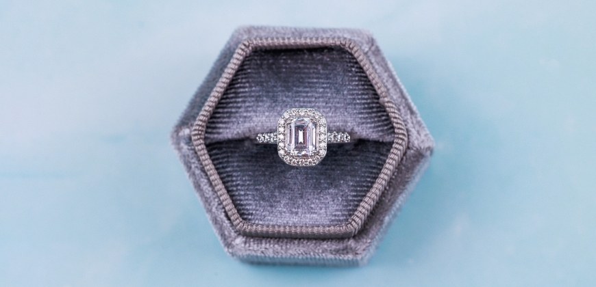 Engagement ring in a box with a blue background