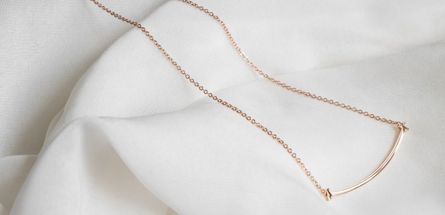 Simple gold necklace on a white background