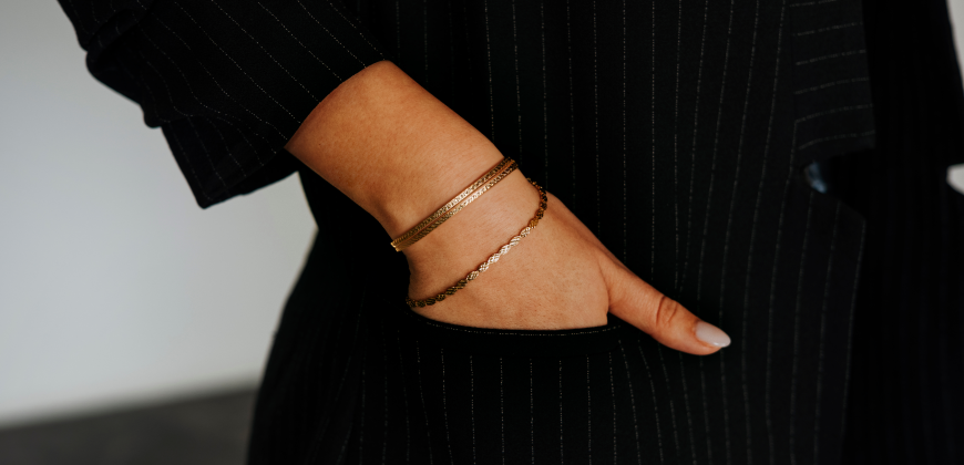 Person with their hands in their pockets wearing gold bracelets