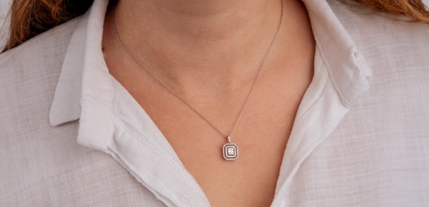 Person wearing a diamond pendant necklace