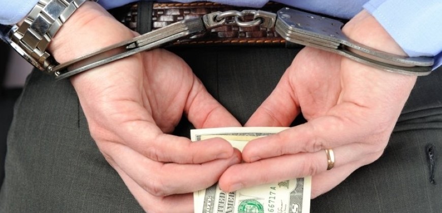 Person in handcuffs holding money