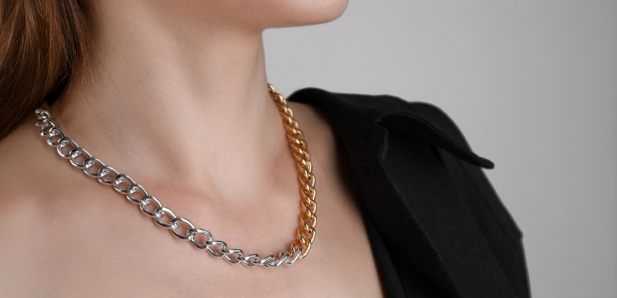 A woman wearing a necklace made of silver and gold