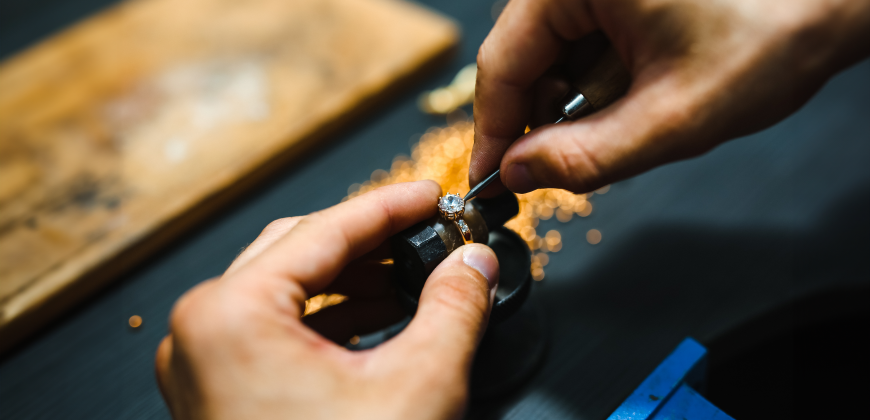 Close up of a jeweler repairing a diamond ring holding tools