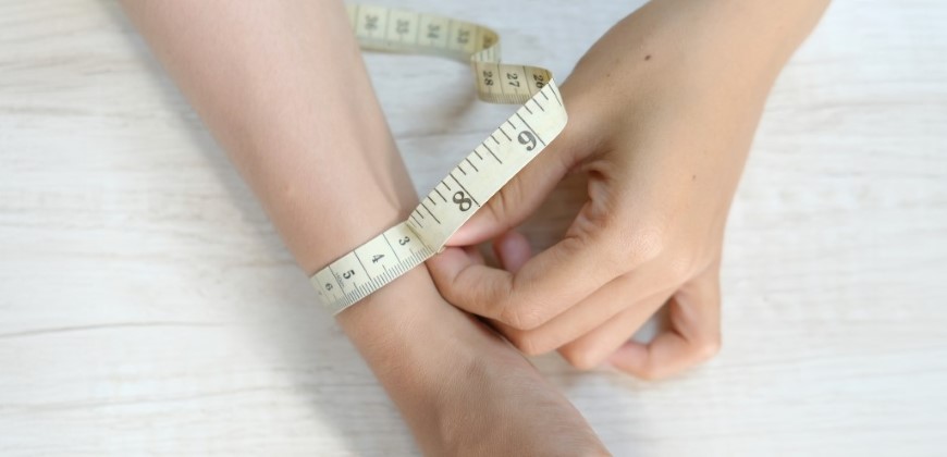 A person measuring their wrist size