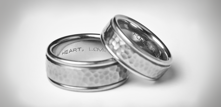 Two hammered wedding bands stacked with engravings inside
