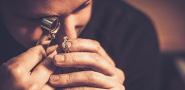 Jeweler looking at a diamond ring close up using a magnifying tool
