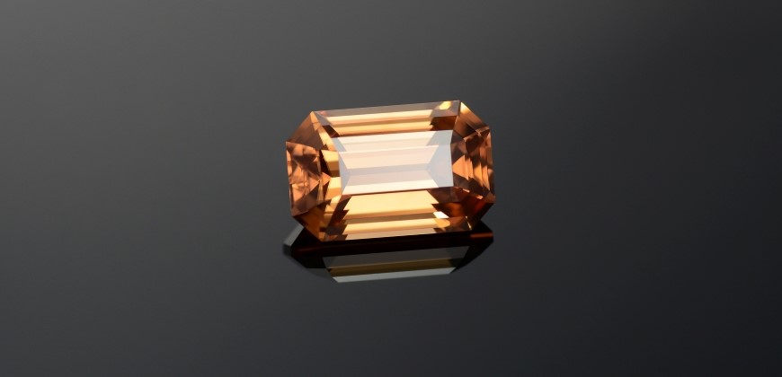 A zircon gemstone up close on a black and grey background