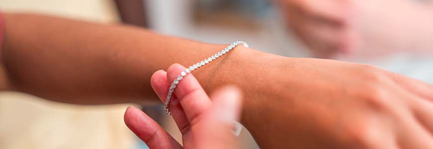 woman tries on dainty diamond bracelet on left hand