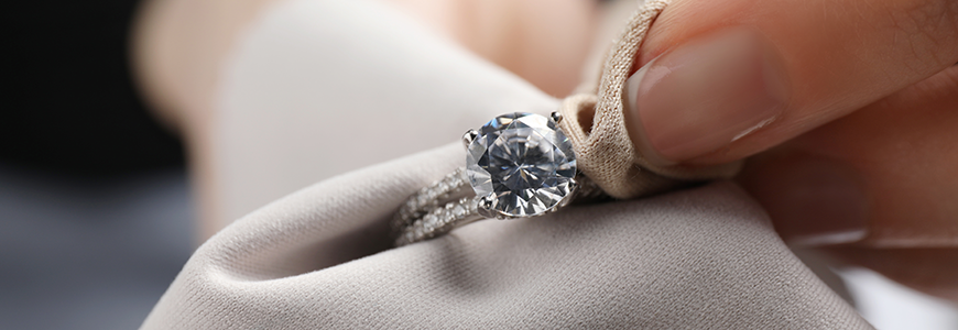 woman cleaning diamond ring with microfiber cloth