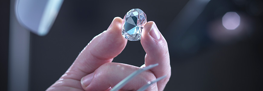 jeweler holds up lozenge cut diamond to light