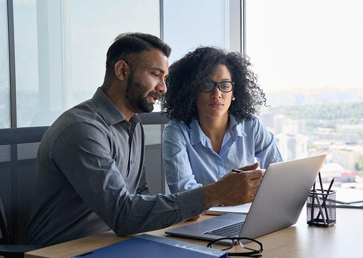 Man and woman collaborating on laptop screen