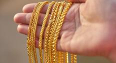 Different gold chains on a persons hand