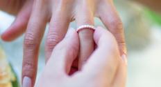 Person putting an eternity ring on their finger