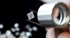 Inspecting a diamond in a tweezers 