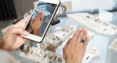Person using their phone camera trying on a ring