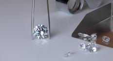 Picture of a diamond in tweezers, diamonds in a metal tray, and microscope