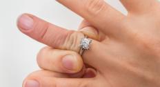 Person trying to pull off a ring stuck on their finger