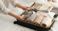 Person packing jewelry into a suitcase 