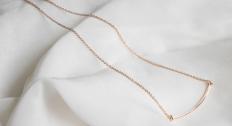 Simple gold necklace on a white background