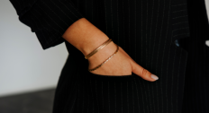 Person with their hands in their pockets wearing gold bracelets