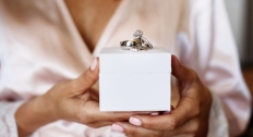 Bride holding a box with wedding rings on top of it