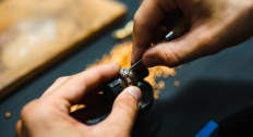 Close up of a jeweler repairing a diamond ring holding tools