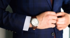 Close up of a person's wrist with a watch matching their suit