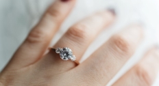 Close up of a three-stone diamond ring on a hand
