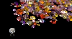 Picture of a colorless diamond with colored diamonds in the background