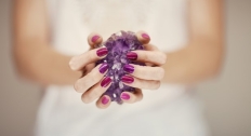 Hands holding an amethyst stone