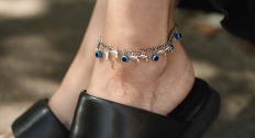 woman with black sandal pumps wears anklet with blue and dolphin charms