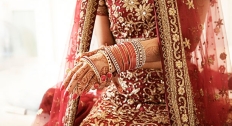 indian woman with henna on her hands slides on gold bracelet