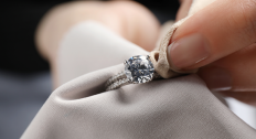 person cleaning diamond ring with microfiber cloth