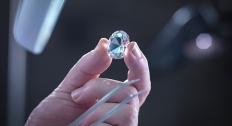 jeweler holds up lozenge cut diamond to light